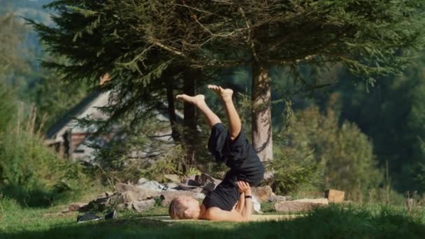 Mujer deportiva entrenando en el bosque de montaña. Chica de yoga acostada en la estera al aire libre. — Vídeo de stock