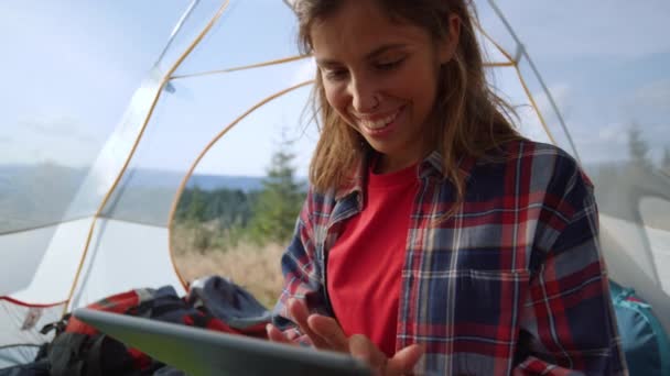 背景に山とテントの中でデジタルタブレット上で女の子のショッピングオンライン — ストック動画