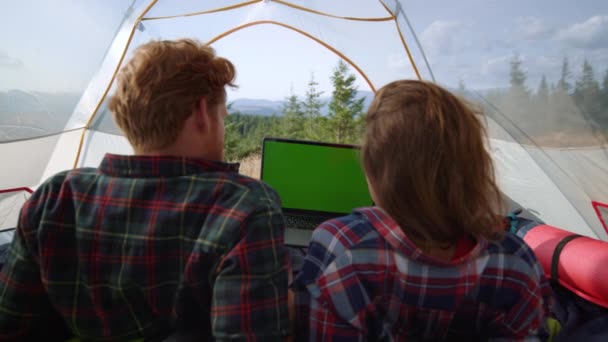 Vista posteriore focalizzata uomo e donna guardando film su laptop con schermo verde — Video Stock