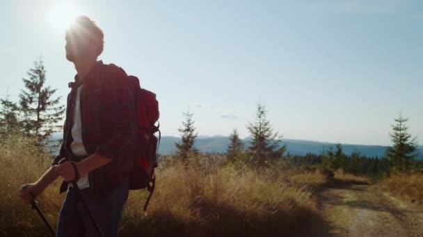 Senderismo turístico masculino en montañas. Pelirroja caminando por la carretera en el campo — Vídeos de Stock