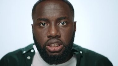 Stüdyoda arka planda bağıran kızgın Afrikalı Amerikalı adamın portresi..