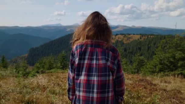 Junge Frau, die allein auf dem Gipfel des Berges steht. Wanderin genießt Urlaub — Stockvideo