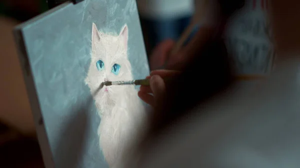 Artista menina irreconhecível desenho imagem de gato branco na lona no estúdio. — Fotografia de Stock