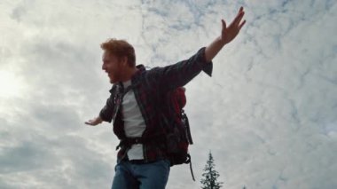 Erkek yürüyüşçü el kaldırıyor. Kızıl saçlı adam dışarıda bağırıyor.