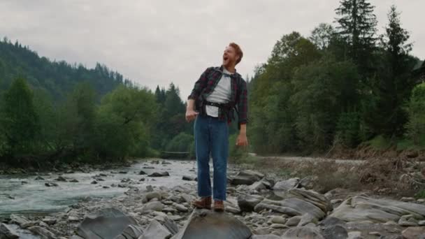 Positive man raising hands in mountain landscape. Male traveler feeling freedom — Stock Video