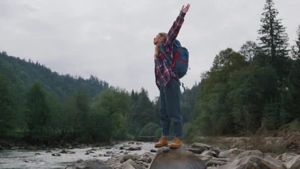 Mujer levantando las manos en el paisaje de montaña. Viajero femenino sintiendo libertad — Vídeo de stock