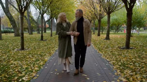 Charmant homme âgé et belle femme qui se regardent dans le parc d'automne. — Video