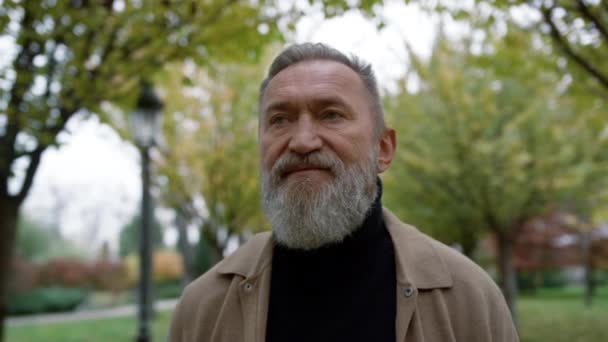 Portret van volwassen man met lange grijze baard buiten. Oude man gaat.. — Stockvideo