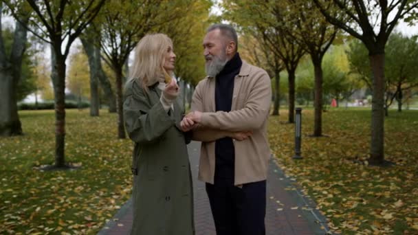 Leende par älskare som har kul med aktiva handgester i höstparken. — Stockvideo