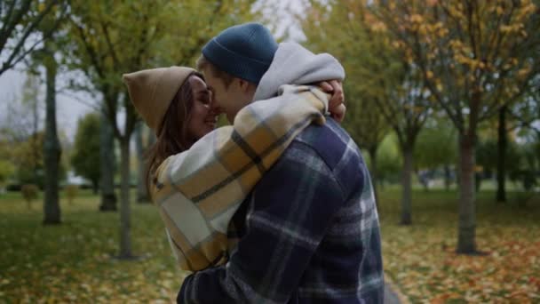 Belos jovens amantes beijando romanticamente no parque de outono. Fechar de par. — Vídeo de Stock