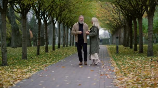 Amplio tiro de sonriente feliz pareja divirtiéndose en hermoso follaje parque. — Vídeo de stock