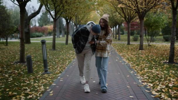 恋爱中的一对快乐的夫妇在树叶公园里欢欢喜喜地散步. — 图库视频影像