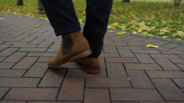 Felismerhetetlen férfi lábak sétálnak az utcán. Szoros férfi csizma a szabadban. — Stock videók
