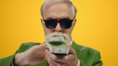Stüdyoda para saçan başarılı bir adam. Yaşlı adam içeride para tutuyor..