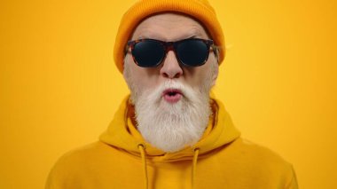 Stüdyoda şaklabanlık yapan neşeli yaşlı adam. Olgun adam içeride dilini gösteriyor..