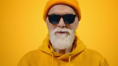 Stüdyoda poz veren mutlu yaşlı adam. İçerde gülümseyen neşeli olgun beyefendi..