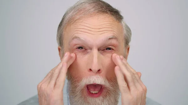 Joyful man grimacing in photo studio. Old guy making funny face indoors. — Stock Photo, Image