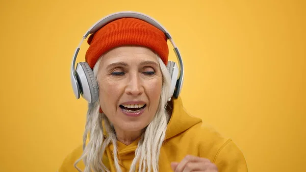 Mujer sonriente escuchando música en auriculares interiores. Dama alegre bailando dentro. — Foto de Stock