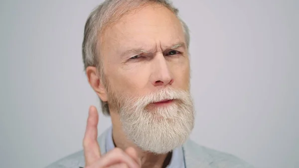 Old man wagging finger in studio. Serious gentleman looking camera indoors. — Stock Photo, Image