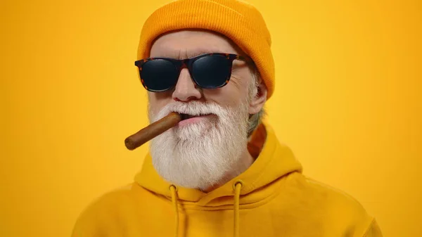 Yaşlanmış kıdemli bir adam modern stüdyoda sigara içerek rahatlıyor.. — Stok fotoğraf