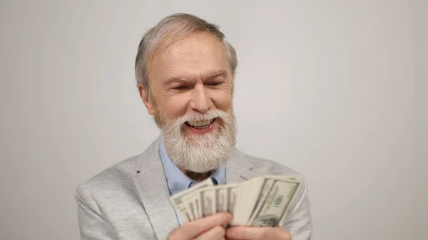 Hombre viejo alegre sosteniendo el dinero en el interior. Viejo divirtiéndose en estudio moderno. —  Fotos de Stock