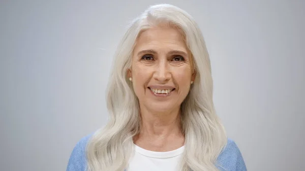 Donna anziana allegra che sembra felice in studio. Signora sana sorridente in casa. — Foto Stock