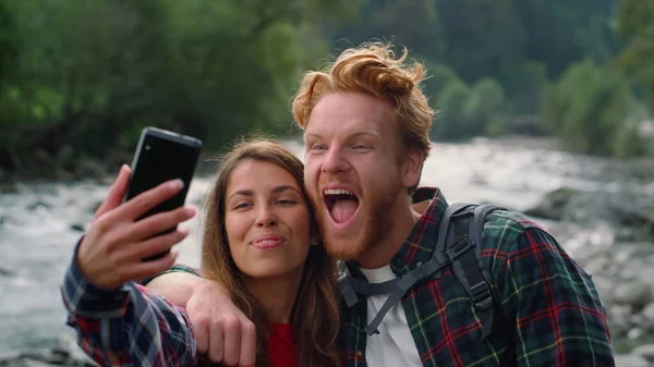 Casal tirando selfie no smartphone. Mulher e homem fazendo caras engraçadas — Fotografia de Stock