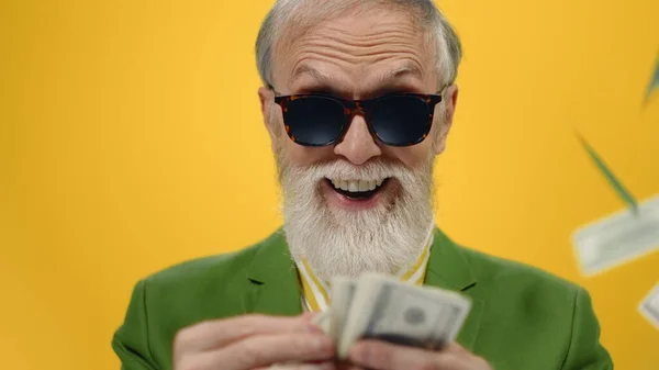 Feliz anciano contando dinero en el estudio. Chico alegre lanzando dólares dentro. —  Fotos de Stock