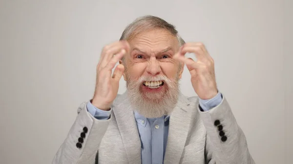 Upprörd äldre man gestikulerar inomhus. Chockad gammal gentleman skriker i studio. — Stockfoto
