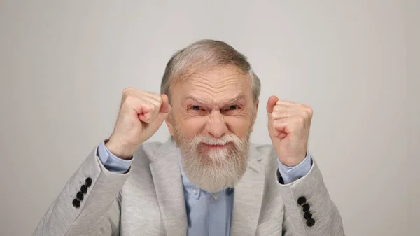 Gokman steekt zijn hand op in de studio. Opgewonden oude man toont emoties binnen. — Stockfoto