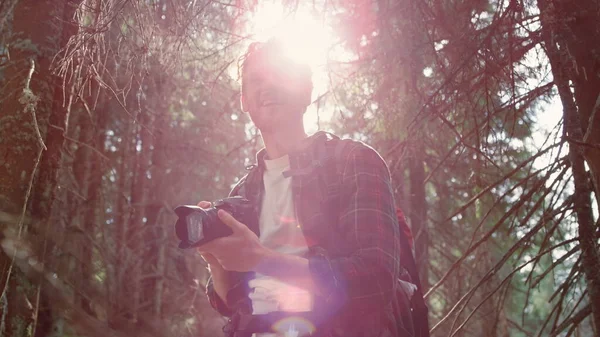 Uomo scattare foto di paesaggio sulla macchina fotografica. Viaggiatore che utilizza la fotocamera fotografica nella foresta — Foto Stock