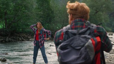 Fotoğrafçı dağdaki kızın fotoğraflarını çekiyor. Kadın komik pozlar veriyor. 