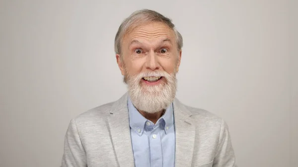 Cheerful man posing to camera in studio. Aged guy celebrating victory indoors. — Stock Photo, Image