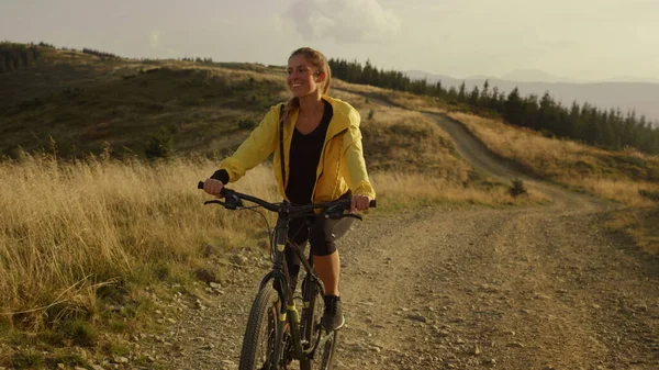 Rider ciclismo su bici sportiva in montagna. Donna sorridente in mountain bike — Foto Stock