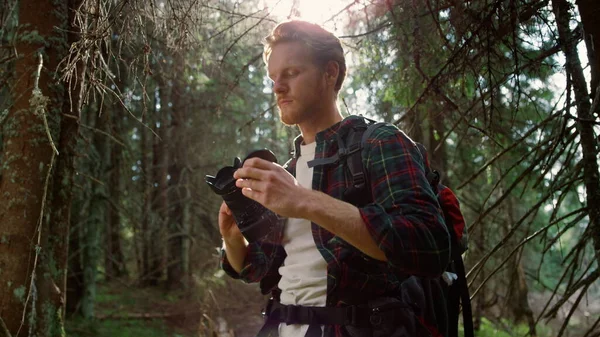 Fotografo con macchina fotografica in piedi nella foresta. Escursionista scattare foto sulla macchina fotografica — Foto Stock