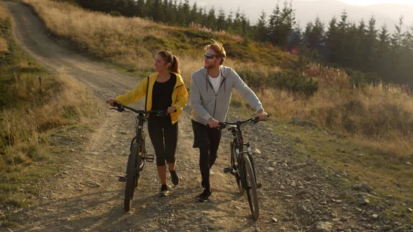 Ciclisti con biciclette a piedi su strada. Giovani ciclisti che parlano all'aperto — Foto Stock