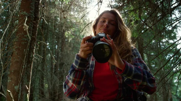 Mujer mirando la cámara. Fotógrafa tomando fotos del paisaje forestal —  Fotos de Stock