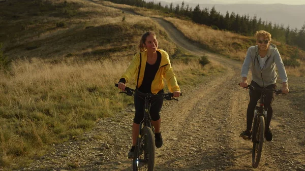 Mujer y hombre en bicicleta en la carretera de montaña. Atletas montando bicicletas deportivas al aire libre — Foto de Stock