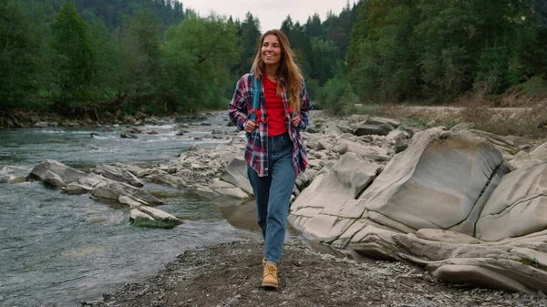 Vrouw wandelend aan de oever van de rivier in het bos. Toeristische rondkijken in de zomer natuur — Stockfoto