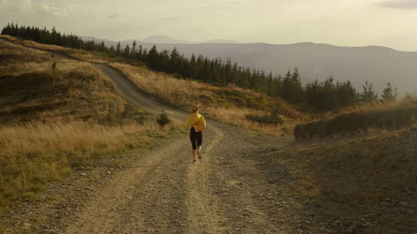 Женщина-спортсмен бежит по дороге в горы. Спортивные женщины тренируются на открытом воздухе — стоковое фото