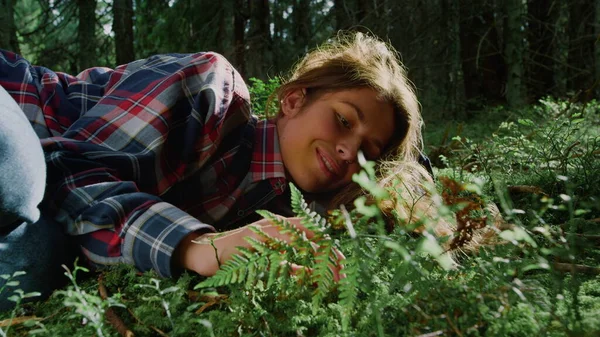 Turistico rilassante sull'erba nella foresta estiva. Giovane donna sdraiata a terra nel bosco — Foto Stock