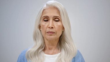 İçten içe gülümseyen yaşlı kadın. Neşeli kadın parmaklarını içeride şaklatıyor..