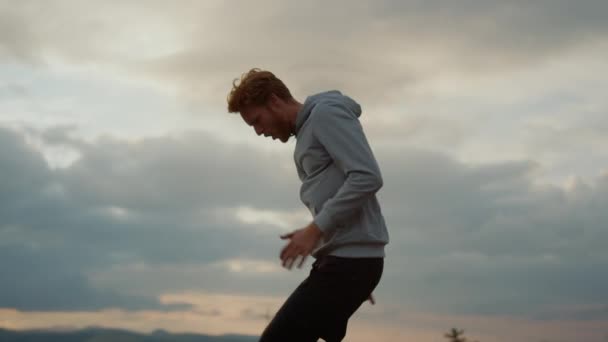 Deportista enfocado haciendo saltos de altura en el lugar. Entrenamiento de deportistas en las montañas — Vídeos de Stock