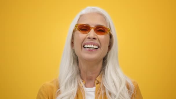 Vrolijke oudere vrouw die binnen lacht. glimlachende dame genieten van het leven in de studio. — Stockvideo