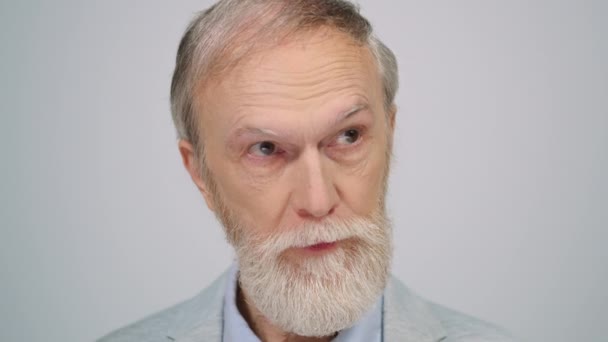 Ernsthafter Mann posiert im Studio vor der Kamera. Älterer Herr fühlt sich drinnen verwirrt. — Stockvideo