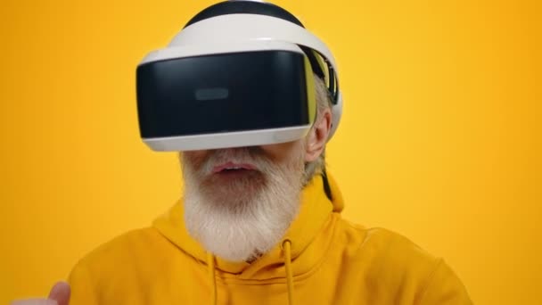 Niesamowity człowiek cieszący się okularami VR w studio. Dojrzałe facet gra w wirtualne urządzenie. — Wideo stockowe