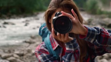 Yürüyüşçü fotoğraf makinesi kullanıyor. Gülümseyen kadın dağ manzarasının fotoğraflarını çekiyor. 