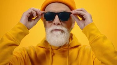 Olgun bir adam kameraya içeride poz veriyor. Neşeli adam stüdyoda yaşam tarzını seviyor..