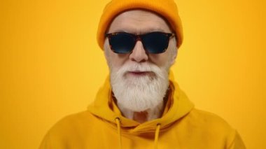 Stüdyoda poz veren mutlu yaşlı adam. İçerde gülümseyen neşeli olgun beyefendi..