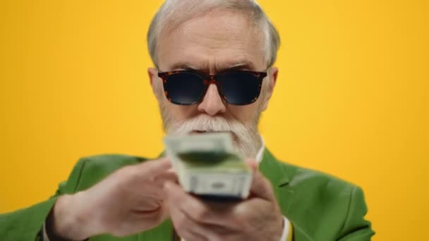 Успішна людина розсіює банкноти в студії. Старий тримає гроші в приміщенні . — стокове відео